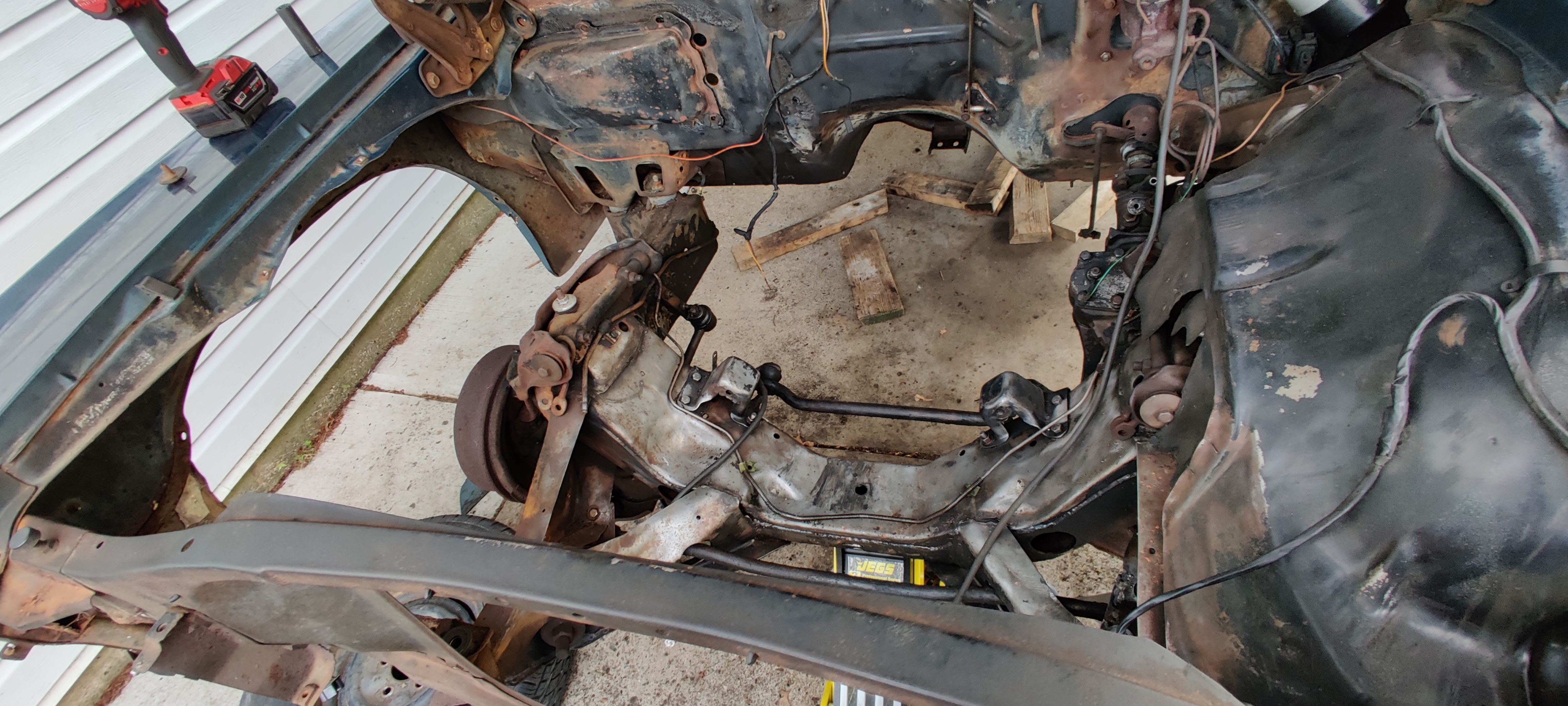 Old rusted out front right wheel well